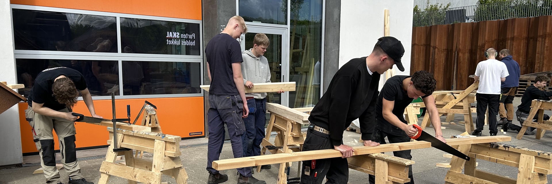 Tømrereleverne arbejder udenfor i solskin om foråret