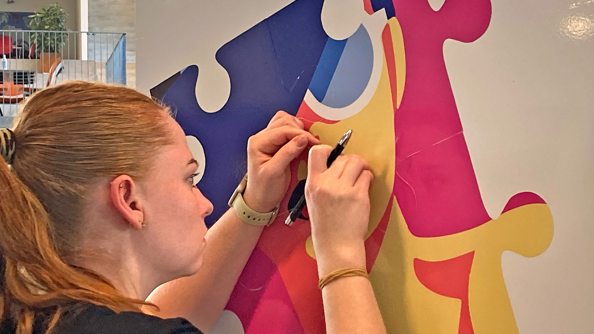 Skiltetekniker arbejder med folie på et skilt