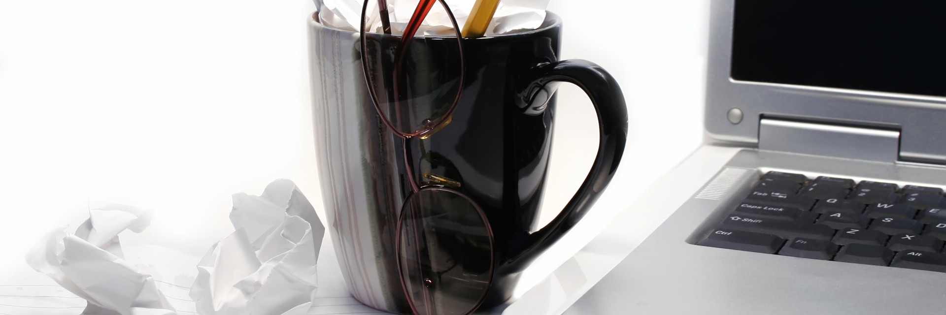 arbejdsplads med computer og kaffekop