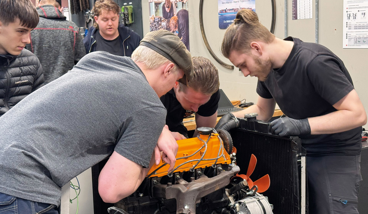Tre drenge arbejder på motor