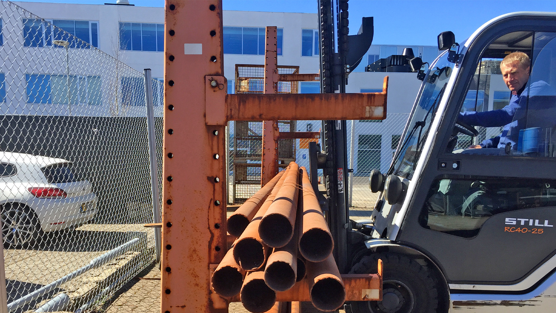 Truckfører løfter jernrør i øvegården under AMU kursus på College360