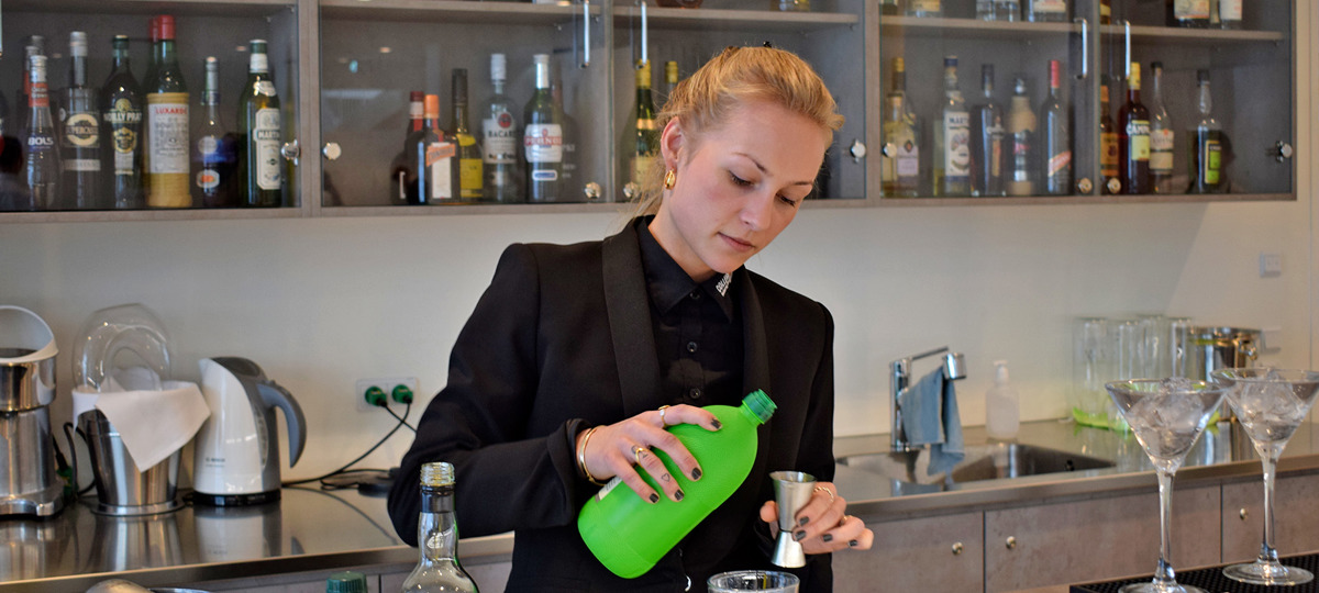 Tjener måler op til cocktails i baren på College360