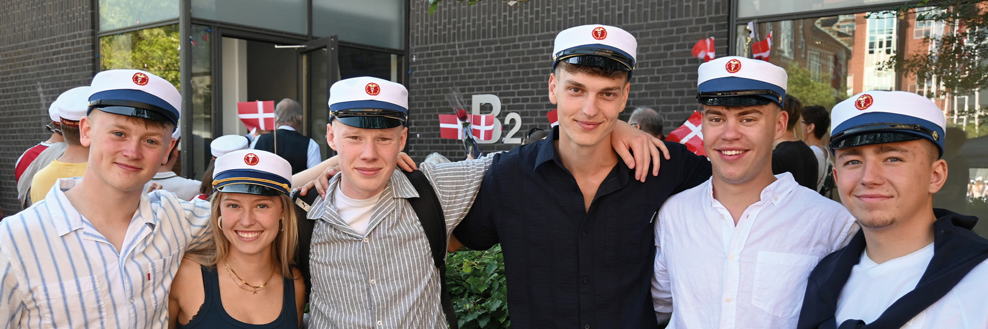 Gruppe af HHX studenter i skolegården under huedagene