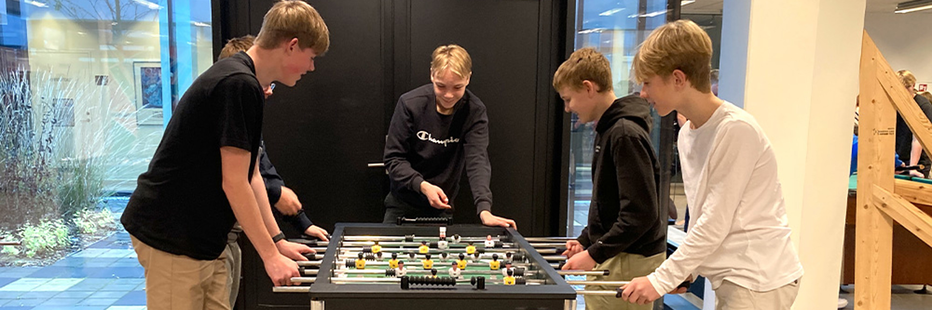 4 drenge spiller bordfodbold i fællesrummet på College360 Bredhøjvej 8