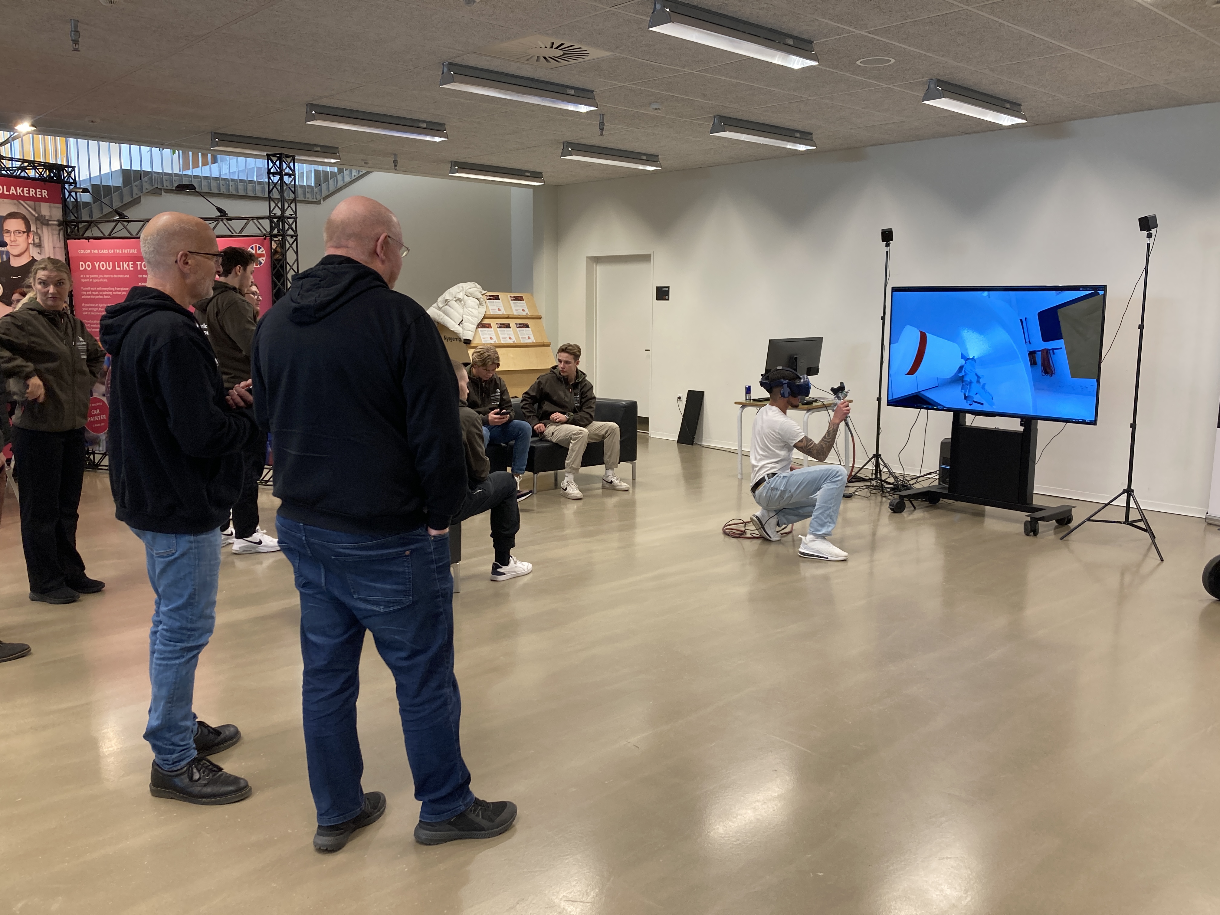 Mennesker kigger på mens elev afprøver laksimulator