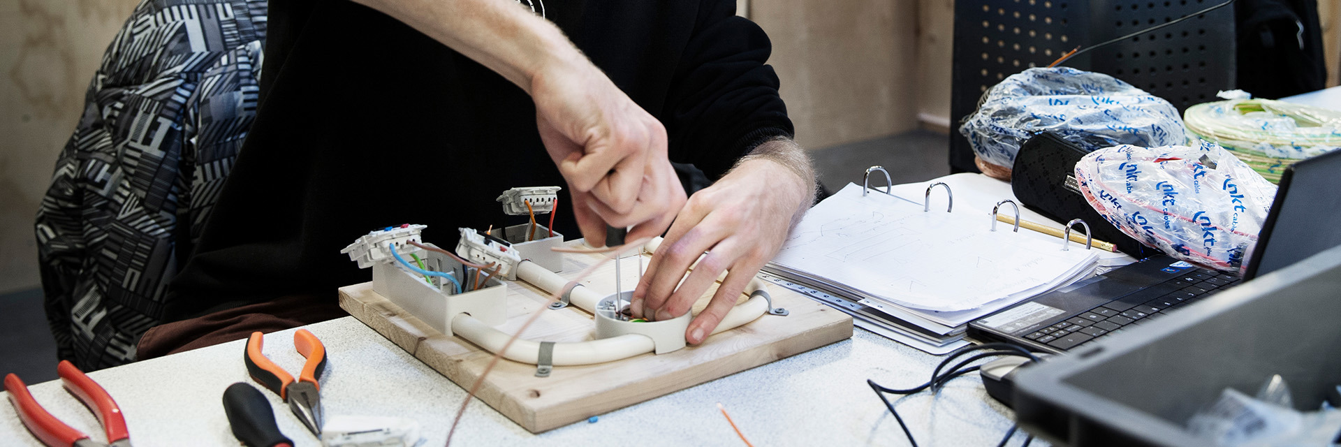 Elektriker skruer i elinstallation på et bord