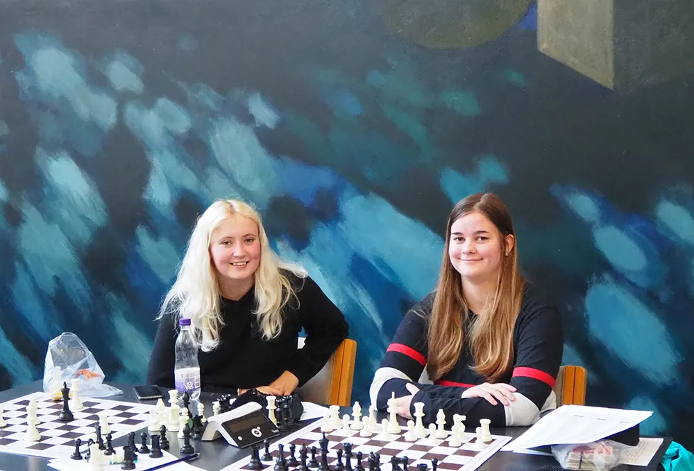 To HTX piger spiller skak i forbindelse med masterclasses foran Sikker Hansen maleri