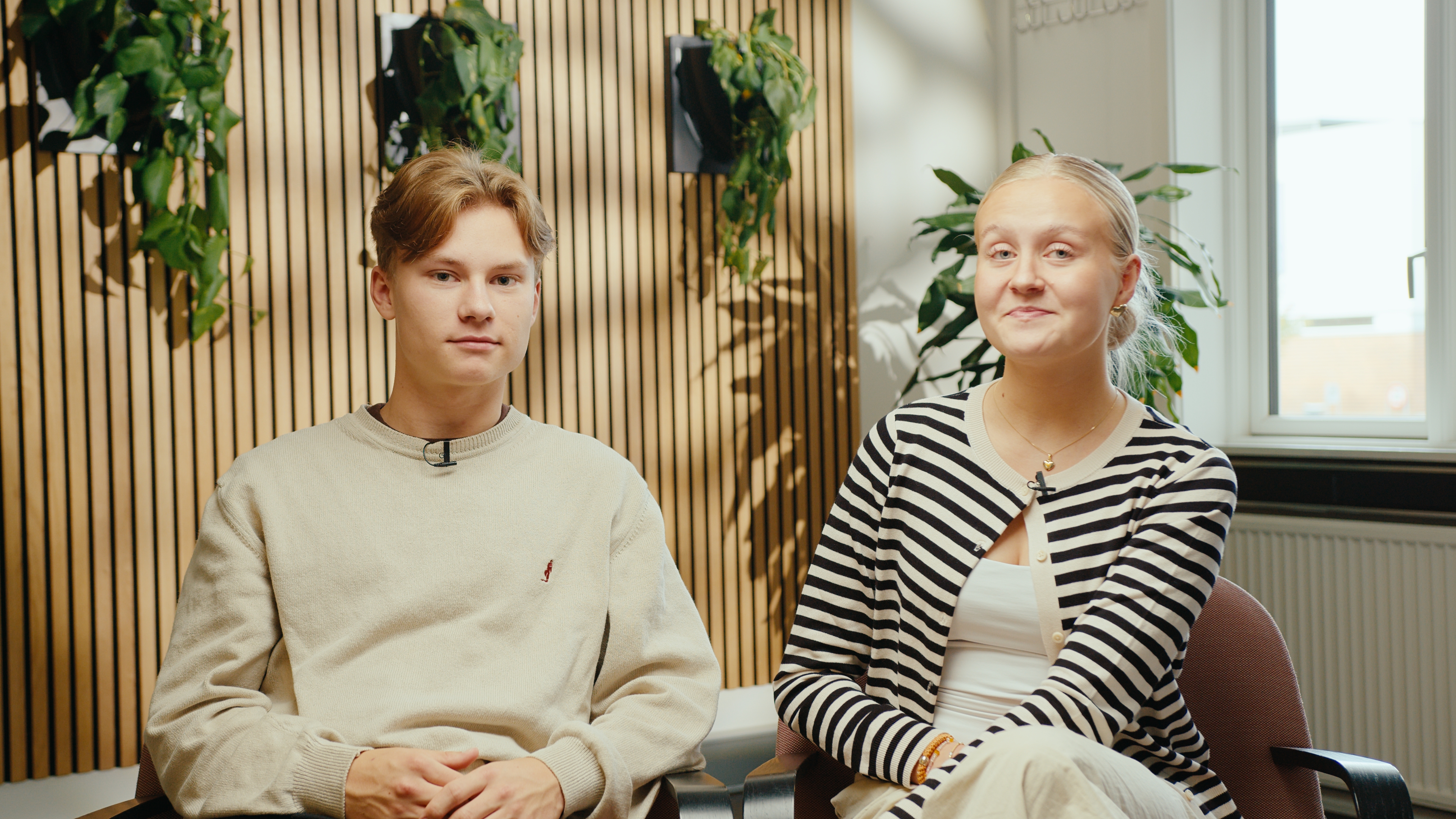 To elever sidder ned og kigger mod kameraet