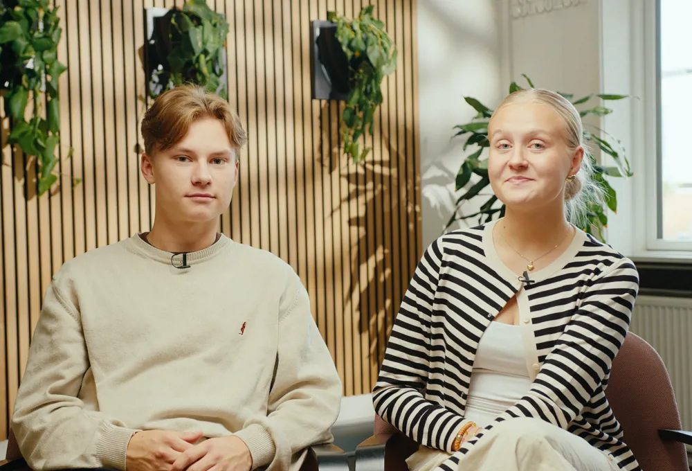 To elever sidder ned og kigger mod kameraet