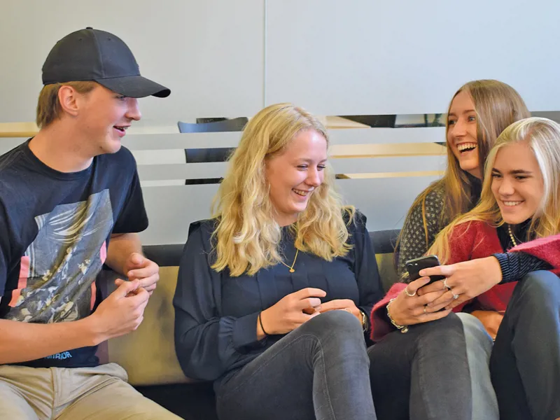 HHX elever griner og hygger med mobiltelefon 